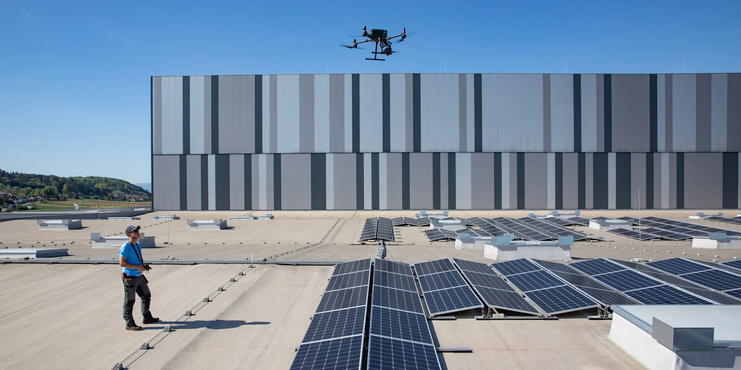 Solarel-Drohnenpilot auf einem großen Flachdach mit Photovoltaik-Anlage
