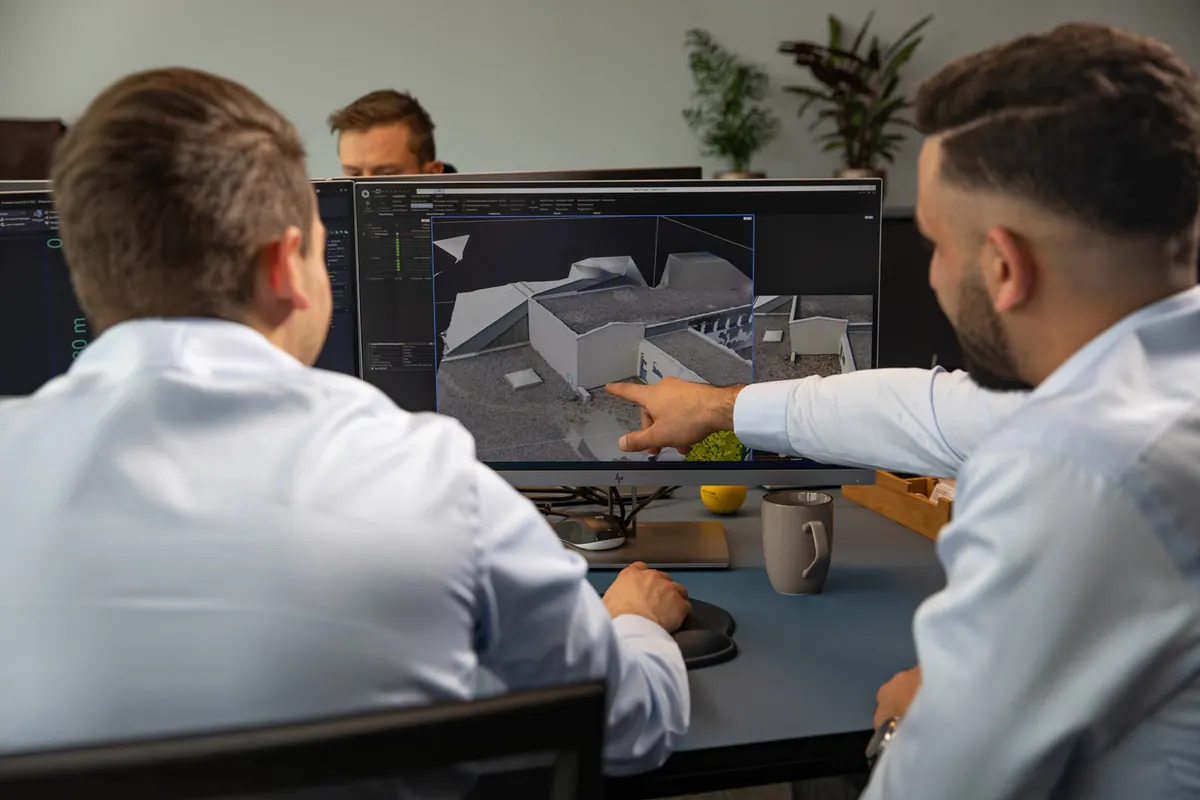 Zwei Solarel-Planer besprechen ein 3D-Dachmodell am Bildschirm